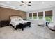 Large bedroom with tray ceiling, ceiling fan, and natural light from multiple windows at 213 Lofty Oak Ln, Holly Springs, NC 27540