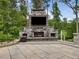 Impressive stone outdoor fireplace and TV, creating a cozy outdoor living space at 213 Lofty Oak Ln, Holly Springs, NC 27540