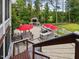 Outdoor kitchen and dining area on a brick patio with a fireplace and views of the backyard at 213 Lofty Oak Ln, Holly Springs, NC 27540