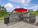 Outdoor kitchen area featuring a built-in grill, storage, and counter space for outdoor dining at 213 Lofty Oak Ln, Holly Springs, NC 27540
