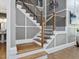 Staircase featuring hardwood stairs, white risers, black metal railings, and hardwood floors at 213 Lofty Oak Ln, Holly Springs, NC 27540