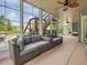 Spacious sunroom with floor-to-ceiling windows, comfortable seating, and a ceiling fan at 213 Lofty Oak Ln, Holly Springs, NC 27540