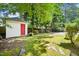 Manicured backyard with a detached storage shed featuring a vibrant red door at 2209 The Circle, Raleigh, NC 27608