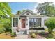 Close-up view of a home's front exterior with a striking red door and black window frames at 2209 The Circle, Raleigh, NC 27608