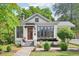 Front exterior of home with brick foundation, red door, black trim and lush landscaping at 2209 The Circle, Raleigh, NC 27608