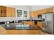 Well-lit kitchen featuring wood cabinets, black countertops, and stainless steel appliances at 2209 The Circle, Raleigh, NC 27608