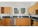 Kitchen features stainless steel appliances, wooden cabinets, and sleek black countertops at 2209 The Circle, Raleigh, NC 27608