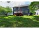 View of back exterior with a stained wood deck, lawn, and a tree-lined back yard at 2309 Filigree Ct, Raleigh, NC 27614