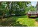 Wide-angle shot of back yard with lawn, wooded area and deck at 2309 Filigree Ct, Raleigh, NC 27614