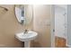 Half bath features a pedestal sink, an oval mirror, and view of the entrance at 2309 Filigree Ct, Raleigh, NC 27614