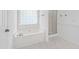 Bathroom featuring a soaking tub, glass enclosed shower, and wainscoting at 2309 Filigree Ct, Raleigh, NC 27614