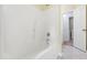 This is a bathtub with white tile and hardware, with a doorway leading to a laundry room at 2309 Filigree Ct, Raleigh, NC 27614