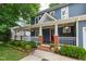 Charming covered front porch with brick columns, white railings, and a beautiful landscaped garden at 2309 Filigree Ct, Raleigh, NC 27614