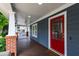 Inviting covered front porch featuring a stained wood floor, ceiling fan, and a charming red door at 2309 Filigree Ct, Raleigh, NC 27614
