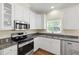 Modern kitchen with granite countertops, stainless steel appliances, and bright white cabinetry at 2309 Filigree Ct, Raleigh, NC 27614
