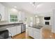 Open kitchen featuring white cabinets, granite countertops, stainless appliances, and an island at 2309 Filigree Ct, Raleigh, NC 27614