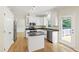 Bright kitchen features white cabinets, granite counters, stainless appliances, and hardwood floors at 2309 Filigree Ct, Raleigh, NC 27614