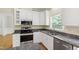 Modern kitchen with granite countertops, stainless steel appliances, and white cabinetry at 2309 Filigree Ct, Raleigh, NC 27614