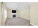 Bright living room featuring a fireplace with mounted TV and neutral carpet at 2309 Filigree Ct, Raleigh, NC 27614