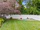 Green backyard with well-kept grass and gardening boxes enclosed by a classic white fence at 2309 Yancey St, Raleigh, NC 27608
