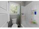 Bright bathroom with a tub-shower featuring white tiles and a window offering natural light at 2309 Yancey St, Raleigh, NC 27608