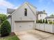 View of detached two car garage, white with carriage style doors and a paved driveway at 2309 Yancey St, Raleigh, NC 27608