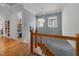 Hallway with hardwood floors leading to a bookshelf and staircase featuring a modern railing at 2309 Yancey St, Raleigh, NC 27608