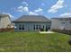 Backyard featuring a well-maintained lawn, privacy fencing, and neighboring homes at 2330 Lazy River Dr, Raleigh, NC 27610