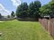 Spacious, lush backyard featuring a tall wood fence and mature trees at 2330 Lazy River Dr, Raleigh, NC 27610