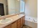 Bathroom featuring double vanity, large mirror and a soaking tub at 2330 Lazy River Dr, Raleigh, NC 27610