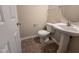 This bathroom features a pedestal sink, toilet, and neutral wall colors at 2330 Lazy River Dr, Raleigh, NC 27610