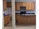 A closer look at the kitchen with oak cabinets and black countertops and appliances at 2330 Lazy River Dr, Raleigh, NC 27610