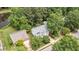 Overhead view of a charming two-story home next to a beautiful pond surrounded by mature trees at 2441 Deanwood Dr, Raleigh, NC 27615