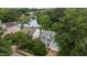 Aerial shot of a gray home near a lake and lush trees in a residential area at 2441 Deanwood Dr, Raleigh, NC 27615