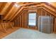 Unfinished attic has exposed rafters, a window, and the floor is mostly covered in green carpet at 2441 Deanwood Dr, Raleigh, NC 27615