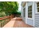 Wooden backyard deck wraps around a gray home with white trim and overlooks lush greenery at 2441 Deanwood Dr, Raleigh, NC 27615