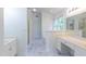 Well-lit bathroom with a separate shower, tub, and dual vanities featuring marble flooring at 2441 Deanwood Dr, Raleigh, NC 27615