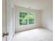 Bright bedroom features neutral carpet, a closet, and a double window overlooking trees at 2441 Deanwood Dr, Raleigh, NC 27615