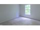Bright bedroom features neutral carpet and a window overlooking the green outdoors at 2441 Deanwood Dr, Raleigh, NC 27615