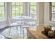 Sun-filled breakfast nook with a round table, transparent chairs, and expansive windows overlooking lush greenery at 2916 Reynolda Cir, Durham, NC 27712