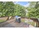 Enjoy outdoor dining on this wooden deck with a grill and beautiful view of the lush greenery at 2916 Reynolda Cir, Durham, NC 27712