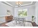 A dining room featuring tray ceilings, an elegant light fixture, and hardwood floors at 2916 Reynolda Cir, Durham, NC 27712