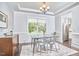 An airy dining space with a modern chandelier, hardwood floors and natural light from a window at 2916 Reynolda Cir, Durham, NC 27712