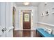 Inviting foyer with hardwood floors, decorative door, and a comfortable bench at 2916 Reynolda Cir, Durham, NC 27712