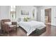 Bright main bedroom with an armchair, hardwood floors, and plenty of natural light from several windows at 2916 Reynolda Cir, Durham, NC 27712