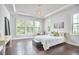 Inviting main bedroom with tray ceiling, large windows, hardwood floors, and a comfortable seating area at 2916 Reynolda Cir, Durham, NC 27712
