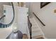 Inviting foyer with carpeted stairs, dark wood handrail, and a decorative mirror adding a touch of elegance at 2921 Imperial Oaks Dr, Raleigh, NC 27614