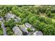 Aerial view of property showing a community surrounded by lush trees near a winding road and pond at 3 Yancey, Pittsboro, NC 27312