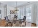 Dining room featuring a glass table, hardwood floors, comfortable upholstered chairs, and large window with sheer curtains at 3 Yancey, Pittsboro, NC 27312