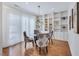 Bright dining room with hardwood floors, large windows with sheer curtains, glass table, and elegant chairs at 3 Yancey, Pittsboro, NC 27312